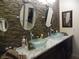 Bathroom featuring dual sinks, granite countertop and stylish stone accent wall at 3781 Desert Marina Dr # 101, Laughlin, NV 89029