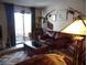 Well-lit living room with comfy leather sofa and sliding glass doors to patio at 3781 Desert Marina Dr # 101, Laughlin, NV 89029