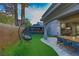 The backyard features a covered patio, outdoor kitchen, lounge area and manicured lawn at 4712 Stavanger Ln, Las Vegas, NV 89147