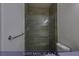 A guest bathroom that features an elegant glass-enclosed shower with wood-style tiling at 4712 Stavanger Ln, Las Vegas, NV 89147
