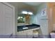 A view of the Primary bathroom vanity with a large mirror, modern lighting, and a stool at 4712 Stavanger Ln, Las Vegas, NV 89147