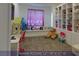 A large, carpeted game room featuring built-in shelves, a window seat and a play area at 4712 Stavanger Ln, Las Vegas, NV 89147