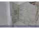 A view of a tiled shower with a shower head and built-in shelf, with a neutral-colored shower curtain at 4712 Stavanger Ln, Las Vegas, NV 89147