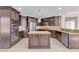 Modern kitchen featuring dark wood cabinets, stainless steel appliances, granite countertops, and a center island at 4933 Gate Fall Ct, Las Vegas, NV 89149