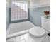 Cozy bathroom features a soaking tub with decorative glass block window and neutral-colored tile at 5050 Grandview Dr, Las Vegas, NV 89120