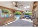Inviting covered patio featuring stucco arches, ceiling fans, and comfortable outdoor seating near the sparkling pool at 5050 Grandview Dr, Las Vegas, NV 89120