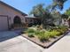 View of the front of house and a large landscaped front yard with flowers and mature trees at 5050 Grandview Dr, Las Vegas, NV 89120