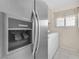 Modern laundry room with stainless steel refrigerator and energy-efficient washer and dryer at 5050 Grandview Dr, Las Vegas, NV 89120