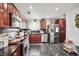 Cherry wood cabinets, stainless steel appliances, and black marble floors make this kitchen standout at 5162 Woodruff Pl, Las Vegas, NV 89120