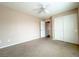 Spacious, carpeted bedroom featuring a ceiling fan and a closet with double doors for ample storage at 5236 El Prado Heights St, North Las Vegas, NV 89081