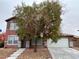 Charming two-story red home with well-maintained landscaping and a two-car garage in a residential neighborhood at 5236 El Prado Heights St, North Las Vegas, NV 89081