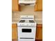 Close-up of white gas range stove and wood cabinets in the kitchen at 5236 El Prado Heights St, North Las Vegas, NV 89081