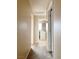 Hallway with beige walls and carpet, leading to a laundry area with a washing machine at 5236 El Prado Heights St, North Las Vegas, NV 89081