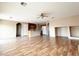 Open-concept living room with wood flooring, a ceiling fan, and an arched doorway leading to the kitchen at 5236 El Prado Heights St, North Las Vegas, NV 89081