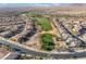 An aerial view of a community featuring a golf course, scenic lake and desert landscaping at 589 Via Medici, Henderson, NV 89011