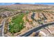 An aerial view of a community with a golf course, scenic mountain backdrop and desert landscaping at 589 Via Medici, Henderson, NV 89011