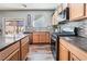 A kitchen with stainless steel appliances, stone countertops, tile backsplash, and wood-style laminate flooring at 589 Via Medici, Henderson, NV 89011