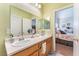 Bathroom with double vanity, large mirror, and access to main bedroom at 6061 Leaping Foal St, North Las Vegas, NV 89081