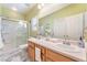 Bathroom with double sink vanity, large mirror, and a shower featuring sleek white finishes at 6061 Leaping Foal St, North Las Vegas, NV 89081