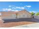 Tan single-story home with desert landscaping in the front yard and a white front door with a wreath at 6061 Leaping Foal St, North Las Vegas, NV 89081