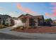 Charming single-story home with a two-car garage, desert landscaping, and a tile roof at sunset at 6061 Leaping Foal St, North Las Vegas, NV 89081