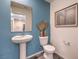 Bathroom featuring a pedestal sink, toilet, framed mirror, and wall decorations at 6173 Aster Garden St # 150, North Las Vegas, NV 89081