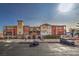 Exterior view of the building with a parking area and cars parked in front of it on a sunny day at 64 Strada Principale # 205, Henderson, NV 89011