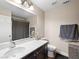 Bright bathroom with a single sink vanity, large mirror, and a shower with a gray curtain at 6627 Bristle Canyon Ave, Las Vegas, NV 89110