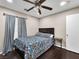 Bedroom with dark wood floors, ceiling fan, and a comfortable bed with floral bedding at 6627 Bristle Canyon Ave, Las Vegas, NV 89110