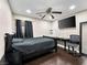 Bedroom featuring a bed, desk, ceiling fan and dark wood floors at 6627 Bristle Canyon Ave, Las Vegas, NV 89110