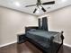 Bedroom featuring dark wood floors, ceiling fan, and a comfortable bed with black bedding at 6627 Bristle Canyon Ave, Las Vegas, NV 89110