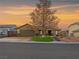 Charming single-story home featuring a two-car garage, landscaped front yard, and desert landscaping at sunset at 6627 Bristle Canyon Ave, Las Vegas, NV 89110