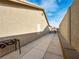 Functional side yard with a concrete path, providing access and utility space alongside the house at 6627 Bristle Canyon Ave, Las Vegas, NV 89110
