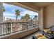 Relaxing balcony with wicker furniture and a view of palm trees and the neighborhood at 7115 S Durango Dr # 308, Las Vegas, NV 89113