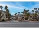 Inviting Vistaña community entrance with palm trees, manicured landscaping, and a decorative entrance gate at 7115 S Durango Dr # 308, Las Vegas, NV 89113
