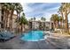 Resort-style pool with lounge chairs surrounded by lush tropical palm trees at 7115 S Durango Dr # 308, Las Vegas, NV 89113