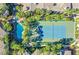 Aerial view of tennis court and pool surrounded by lush greenery at 7115 S Durango Dr # 313, Las Vegas, NV 89113