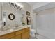 Bright bathroom with a tub and shower combination, light wood vanity, and decorative accents at 7115 S Durango Dr # 313, Las Vegas, NV 89113
