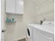 Laundry room equipped with white washer and dryer, overhead storage and wire shelves at 7115 S Durango Dr # 313, Las Vegas, NV 89113