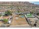 Aerial view of the property with a large dirt lot, pool, putting green and mountain views at 723 Spanish Dr, Las Vegas, NV 89110