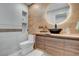 Stylish bathroom with a wood vanity, vessel sink, round LED mirror, and contemporary tile accents at 723 Spanish Dr, Las Vegas, NV 89110