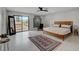 Spacious bedroom with modern decor, including a sleek bed frame, tile floors, and sliding glass door at 723 Spanish Dr, Las Vegas, NV 89110