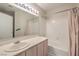 Bathroom featuring a single sink vanity, a shower-tub combo, and modern light fixtures at 7909 Fossil Creek Ln # 202, Las Vegas, NV 89145