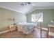 Cozy bedroom featuring wood-look floors, a ceiling fan, and ample natural light from the window at 7909 Fossil Creek Ln # 202, Las Vegas, NV 89145