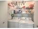 A laundry closet with a front load washing machine and dryer, shelving, and storage for detergents and softeners at 7909 Fossil Creek Ln # 202, Las Vegas, NV 89145