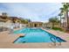 Community pool surrounded by lounge chairs, landscaping, and palm trees on a bright day at 833 Aspen Peak Loop # 712, Henderson, NV 89011