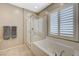 Bathroom featuring a shower and soaking tub combo, with shuttered window at 8562 Insignia Ave # 102, Las Vegas, NV 89178