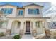 Charming two-story home featuring a welcoming front porch with stone accents and blue shutters at 8562 Insignia Ave # 102, Las Vegas, NV 89178
