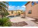 Backyard featuring a pool and outdoor seating area with lush tropical landscaping at 8925 Rio Verde Ave, Las Vegas, NV 89147