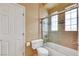 Bathroom featuring a shower-tub combo with glass door and tiled accents at 8925 Rio Verde Ave, Las Vegas, NV 89147
